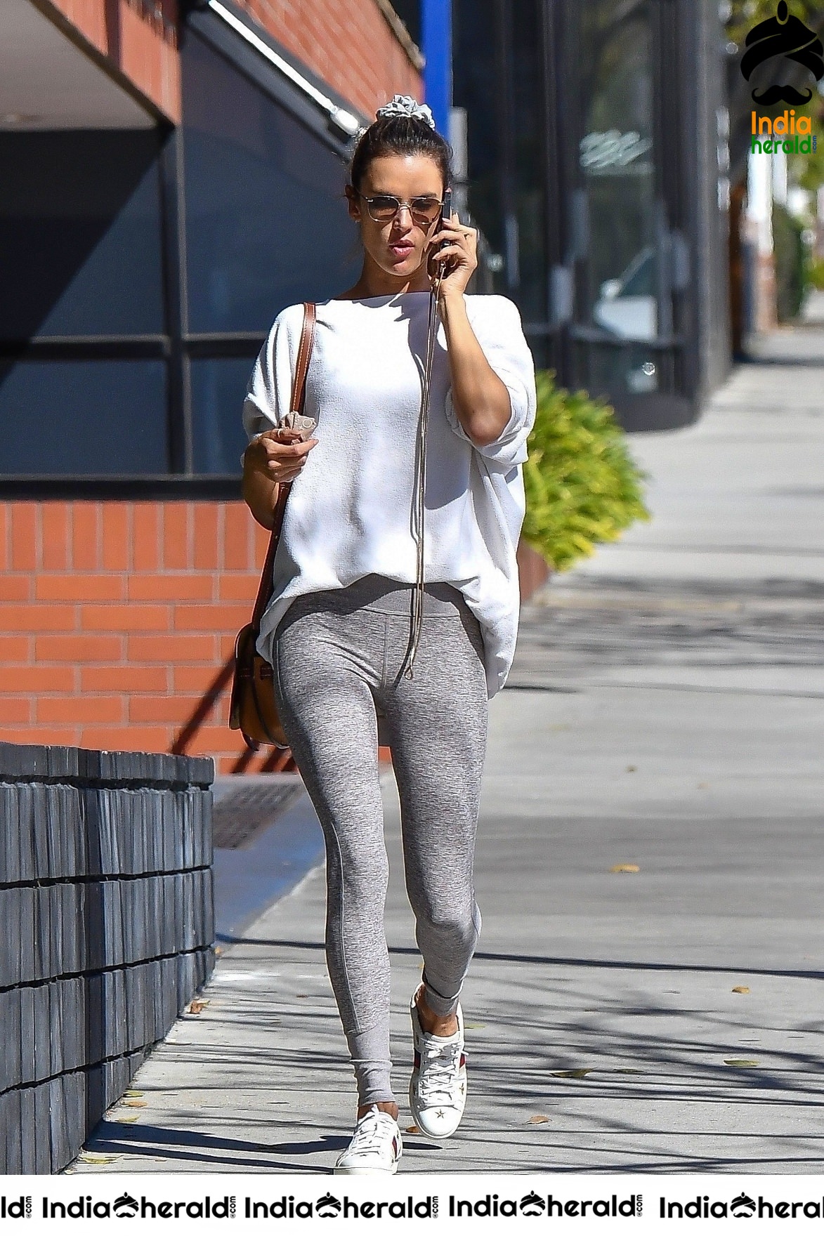 Alessandra Ambrosio chats on her phone as she arrives at a pilates class in LA