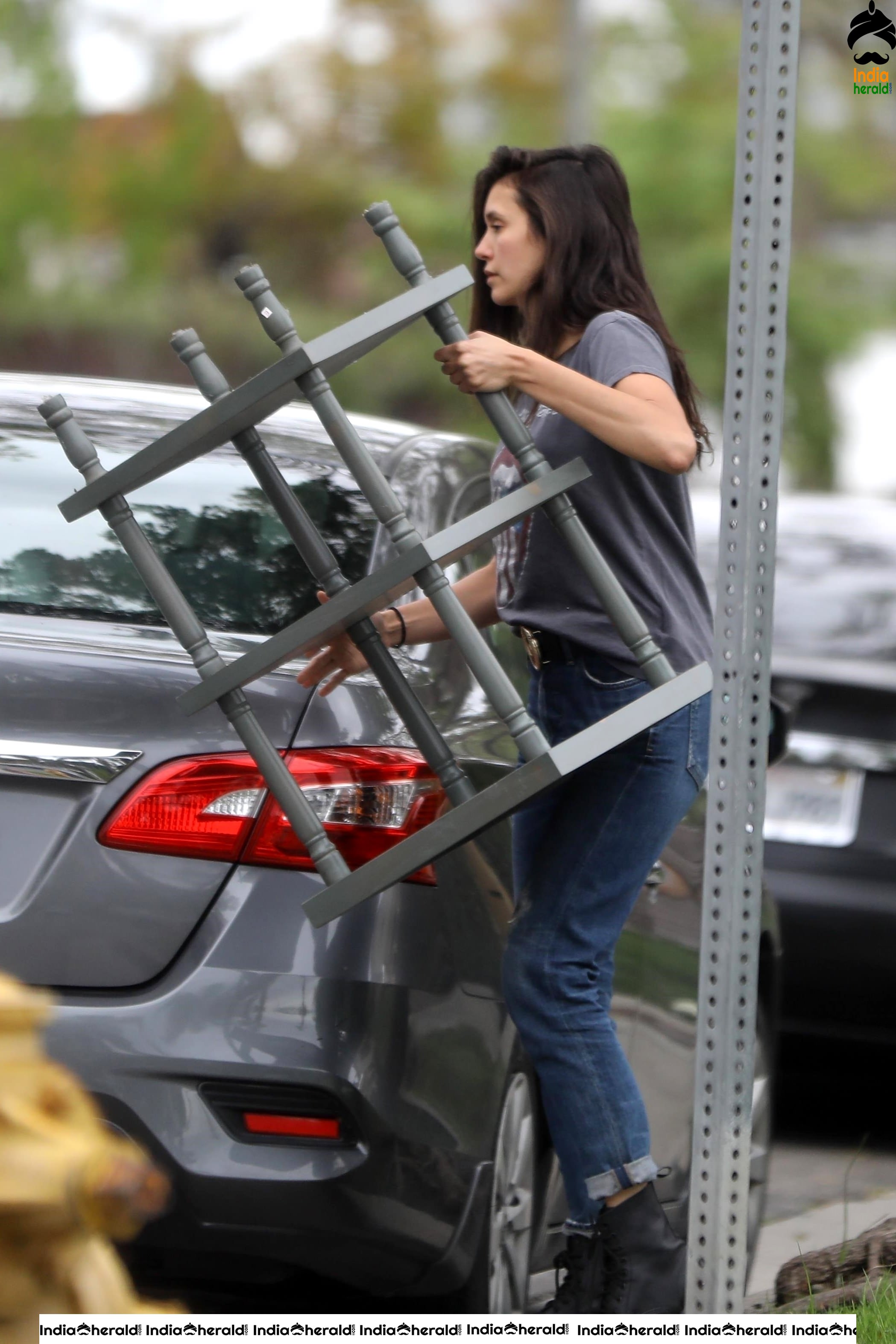 Nina Dobrev caught by Paparazzi while carrying furniture to a car in Los Angeles