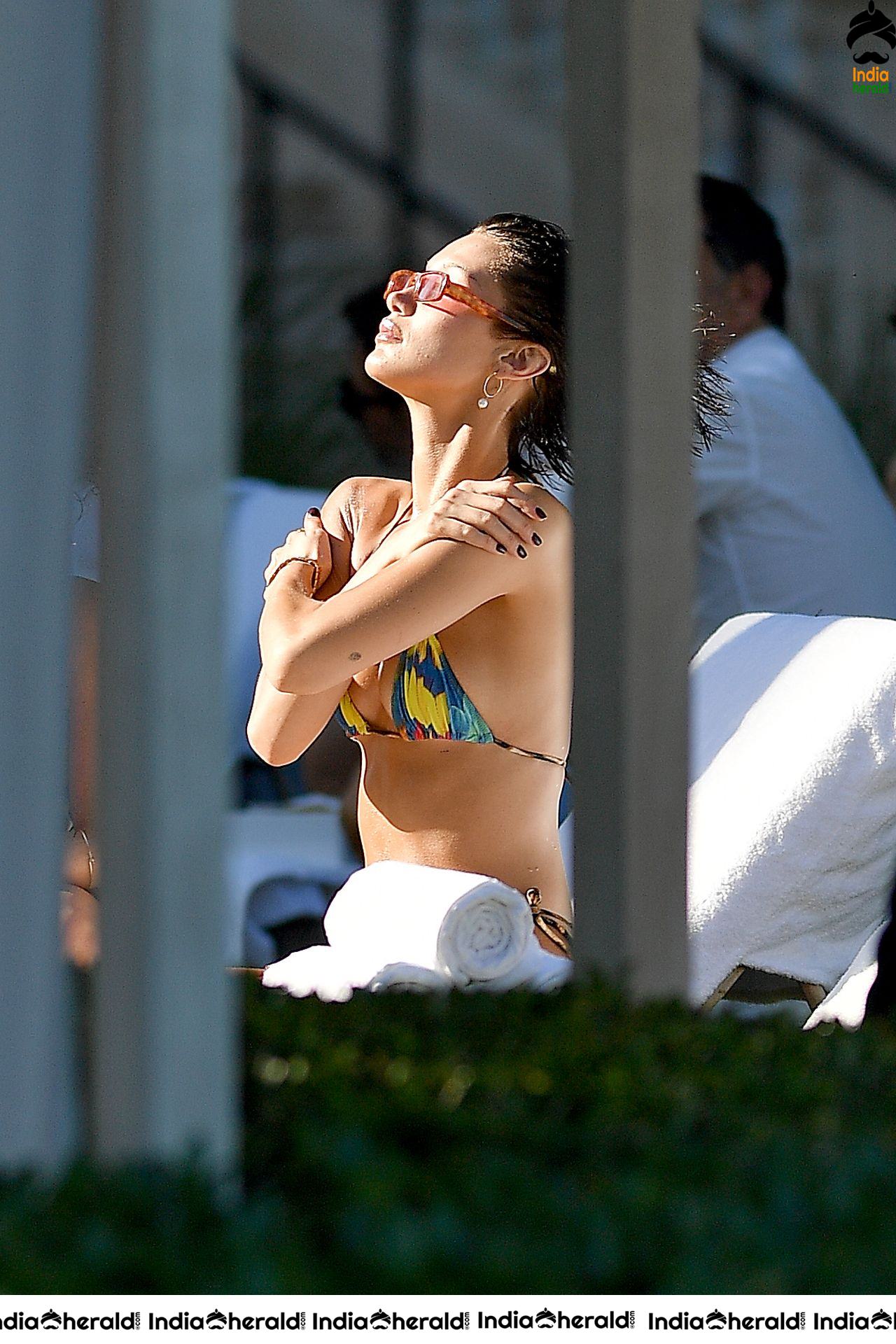 Bella Hadid in a tiny rainbow bikini at a poolside in Miami Beach