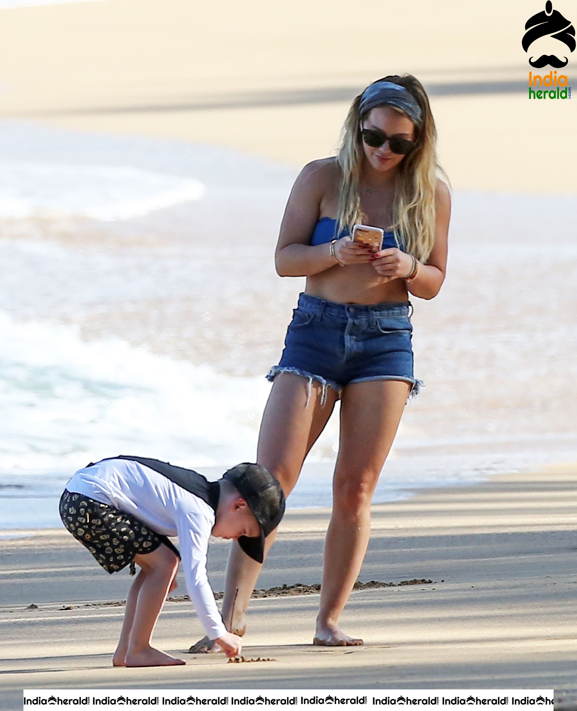 Hilary Duff Wearing a bikini top and shorts at the beach in Hawaii Set 1