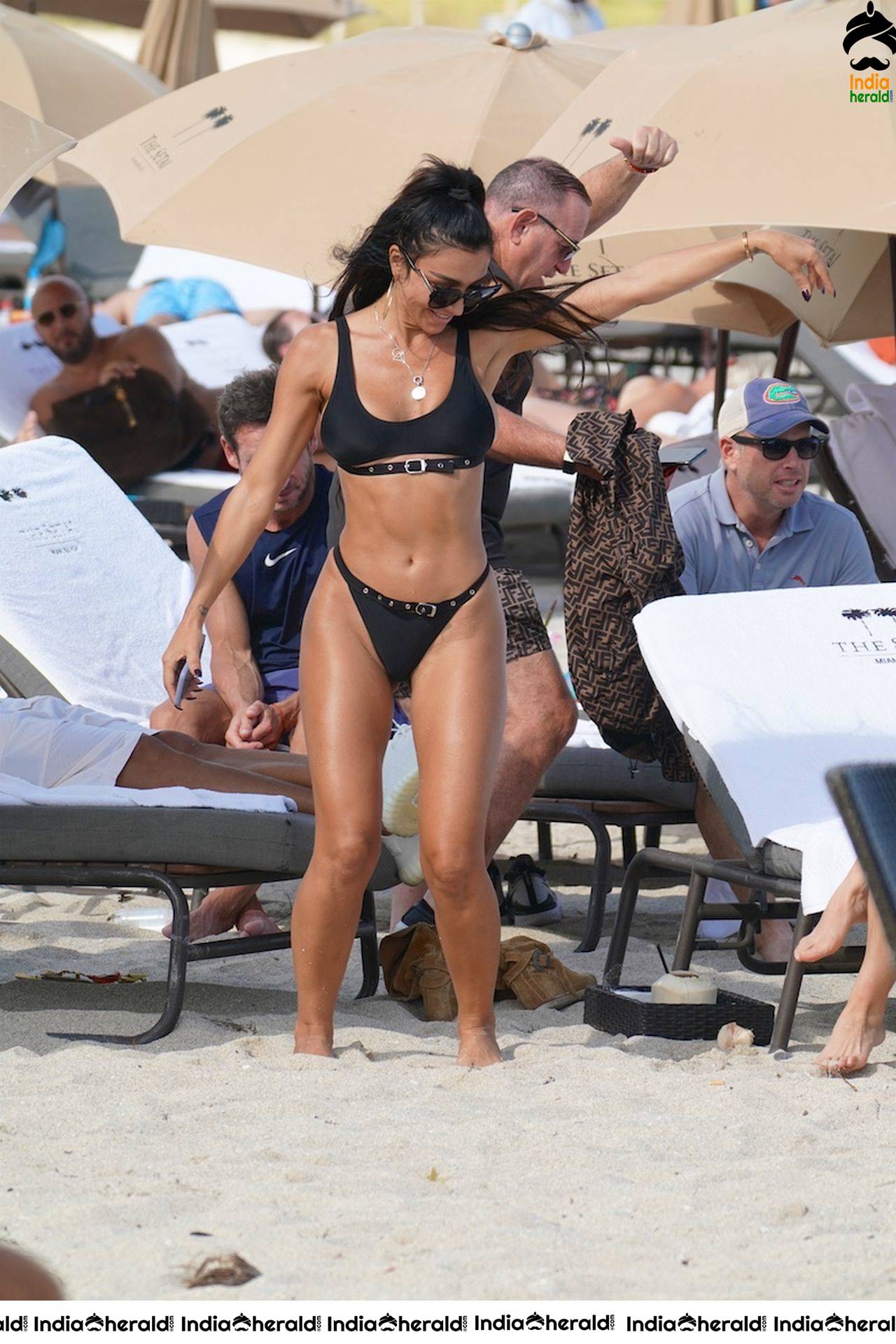 Metisha Schaefer in a black bikini at the beach with friends in Miami Beach