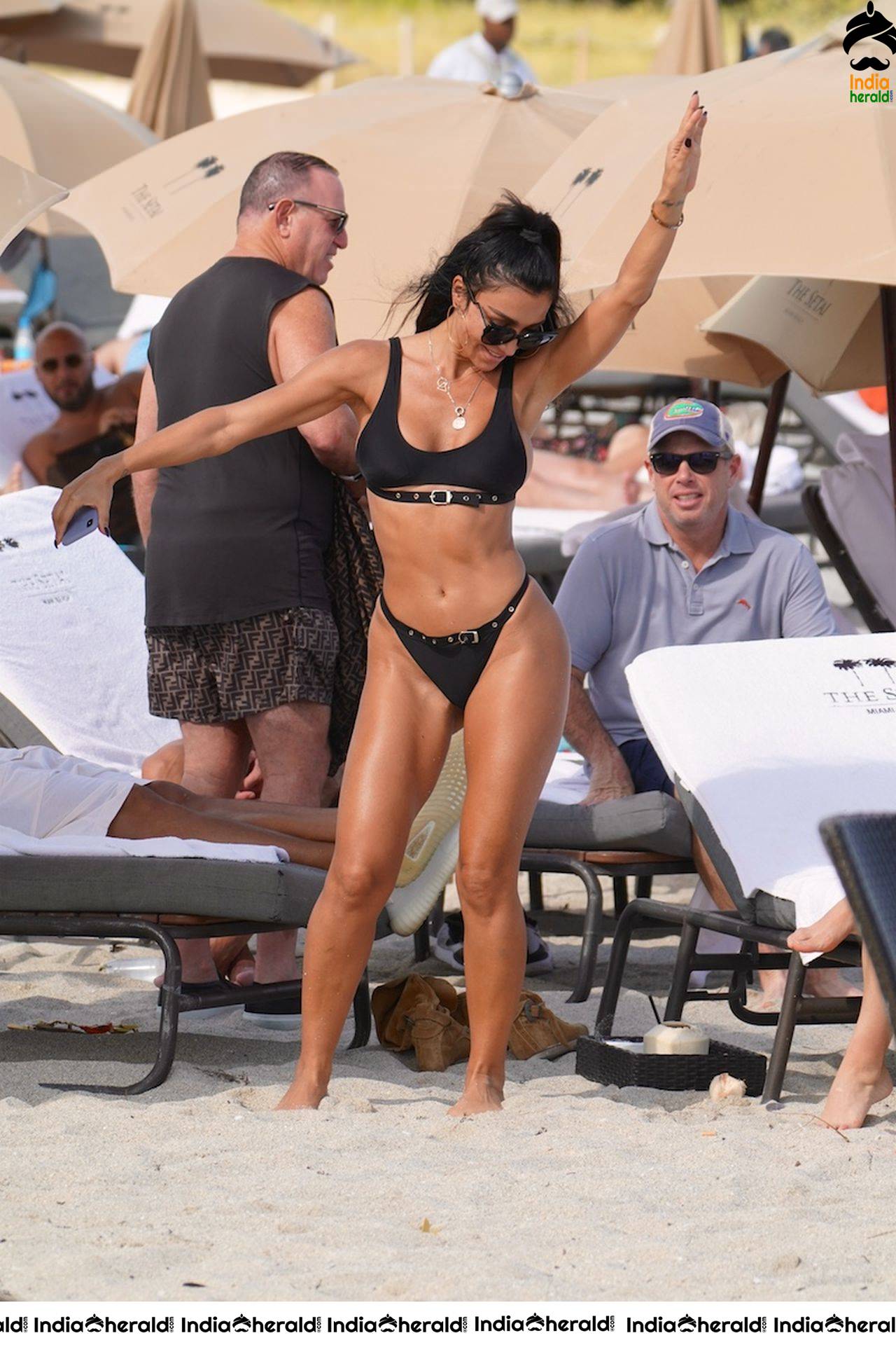 Metisha Schaefer in a black bikini at the beach with friends in Miami Beach