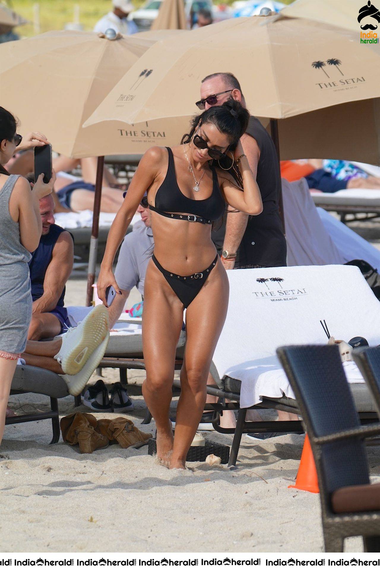 Metisha Schaefer in a black bikini at the beach with friends in Miami Beach