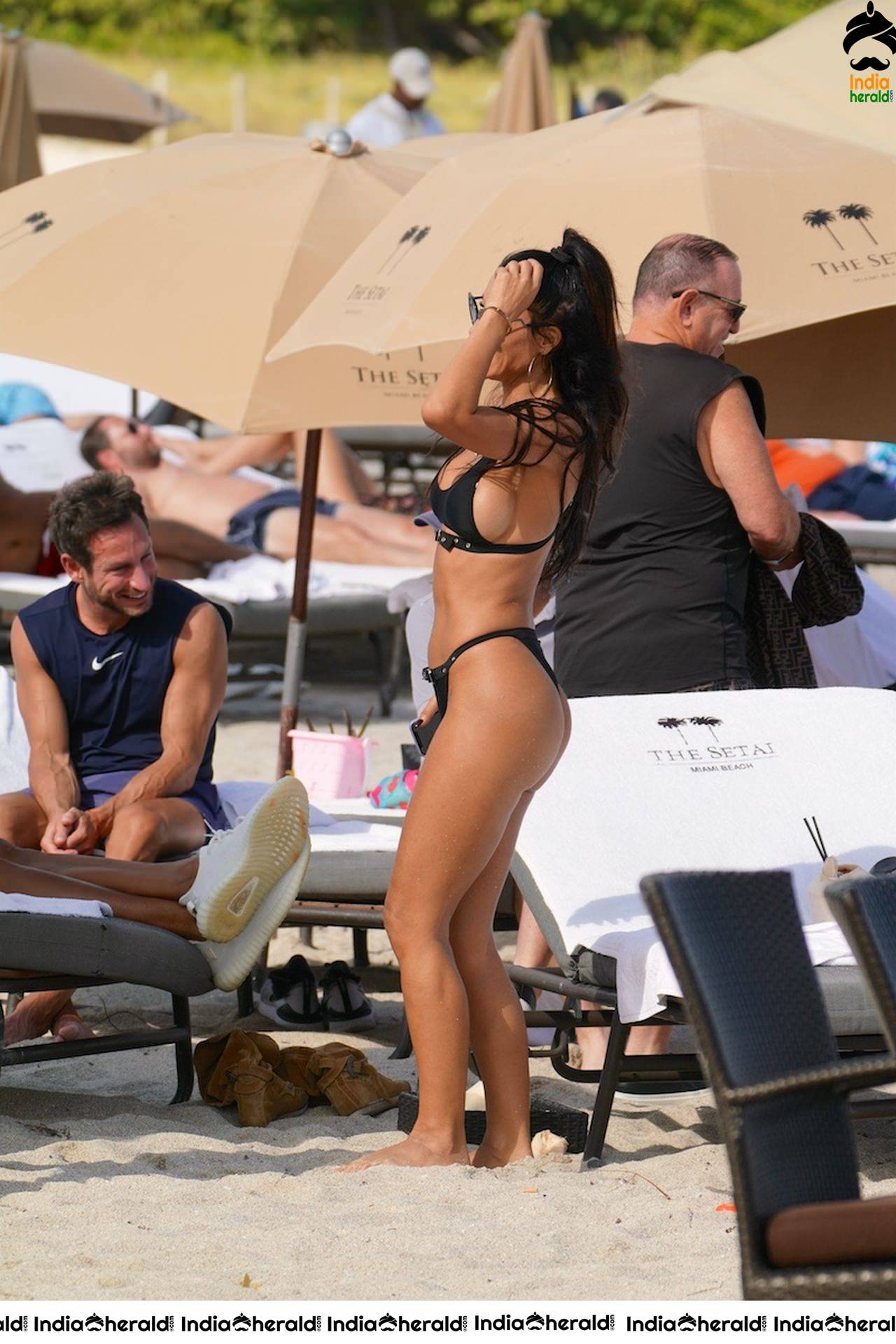 Metisha Schaefer in a black bikini at the beach with friends in Miami Beach