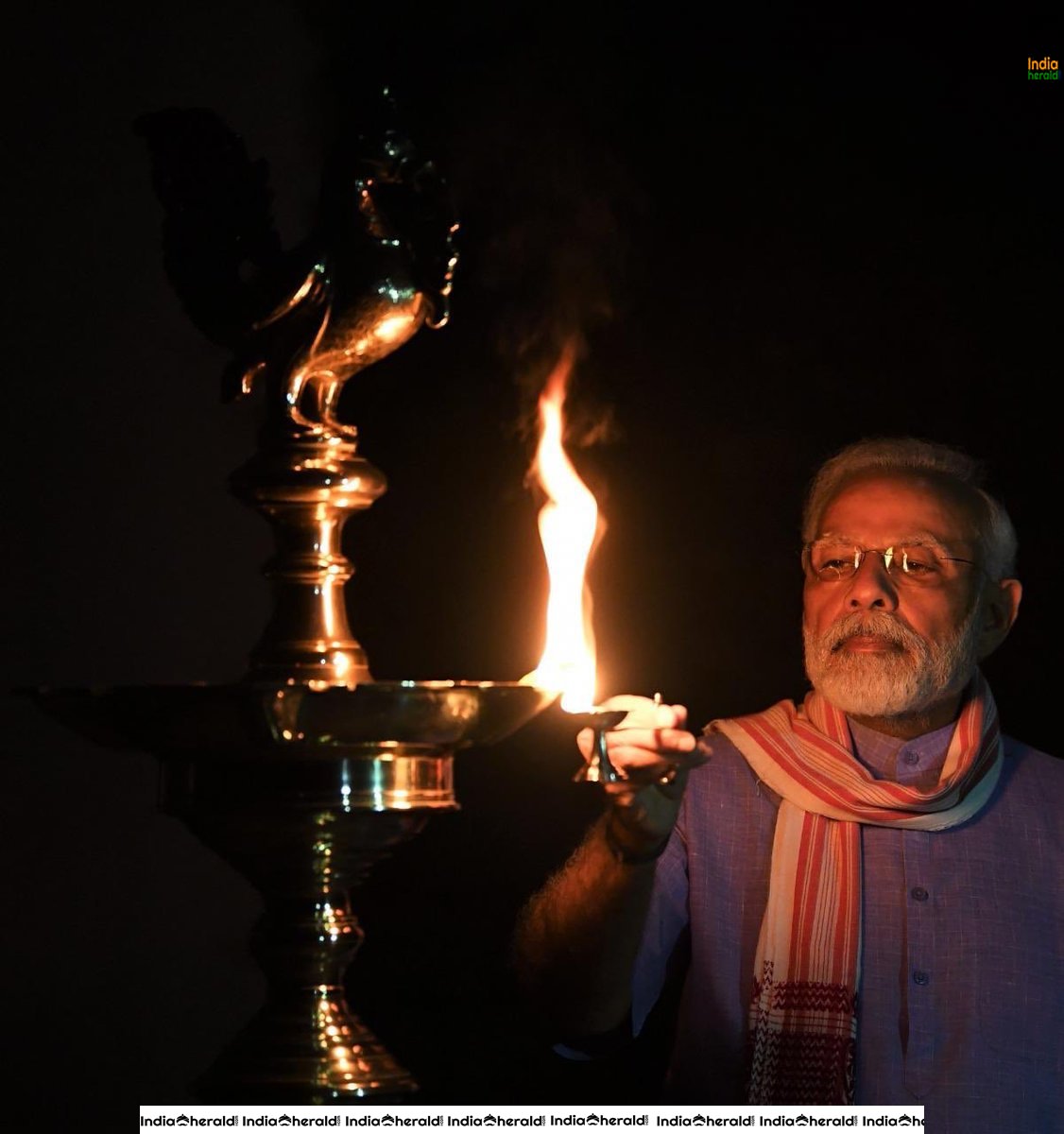 PM Modi lights a lamp after turning off all lights at his residence to mark India fighting against Corona Virus