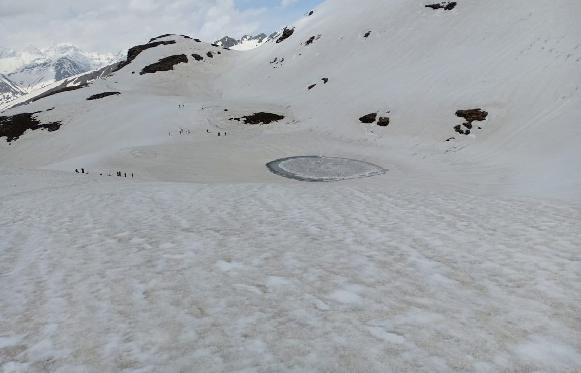Tourists Enjoy Snow Clad Mountains Near The Frozen Bhrigu Lake