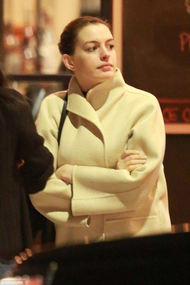 Pregnant Anne Hathaway wraps her growing bump under a chic cream coat