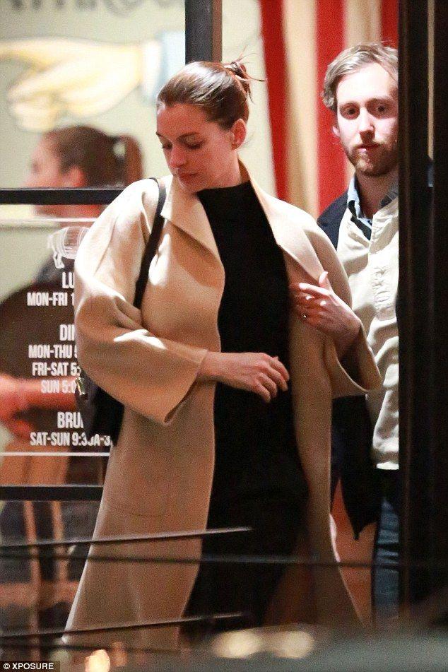 Pregnant Anne Hathaway wraps her growing bump under a chic cream coat
