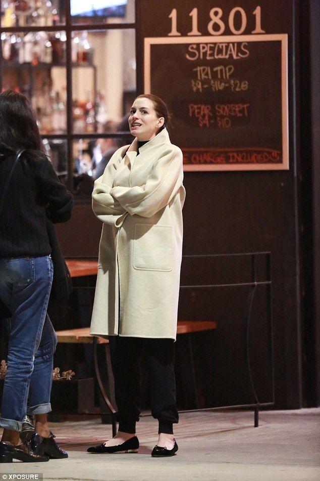 Pregnant Anne Hathaway wraps her growing bump under a chic cream coat