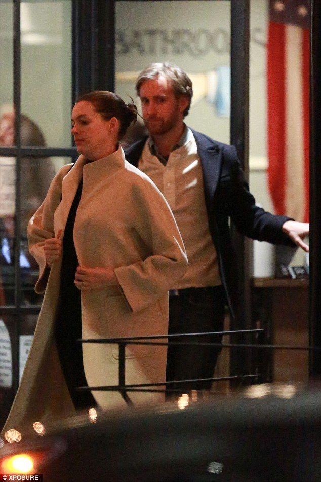 Pregnant Anne Hathaway wraps her growing bump under a chic cream coat