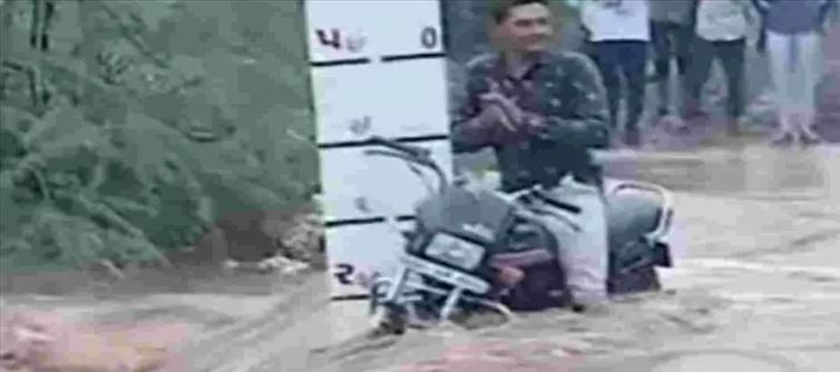 బైక్ తో సహా వరదల్లో చిక్కుకున్నాడు.. అయినా అతనేం చేస్తున్నాడు చూడండి?